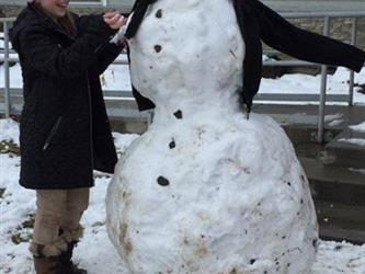 students posing with snowman