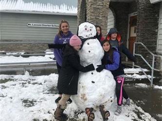 students posing with snowman