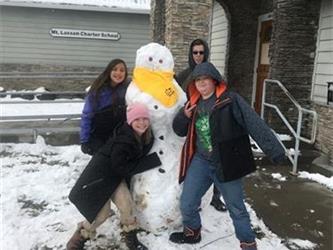 students posing with snowman