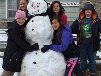 students posing with snowman